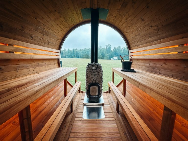 Interior of a wooden barrel sauna with a stove.